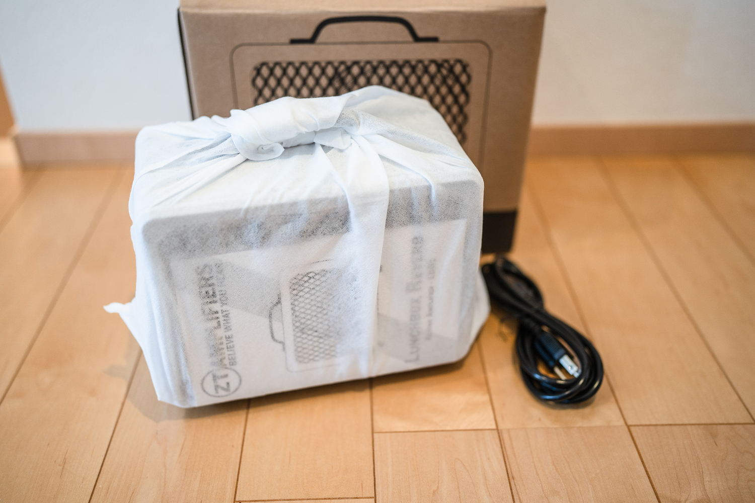 開封。アンプ本体は白い不織布で包まれています。電源ケーブル付き。